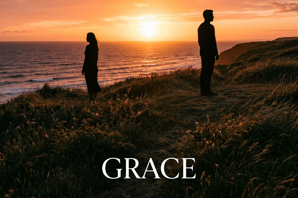 Silhouettes of a man and woman standing on a grassy cliff by the ocean during sunset